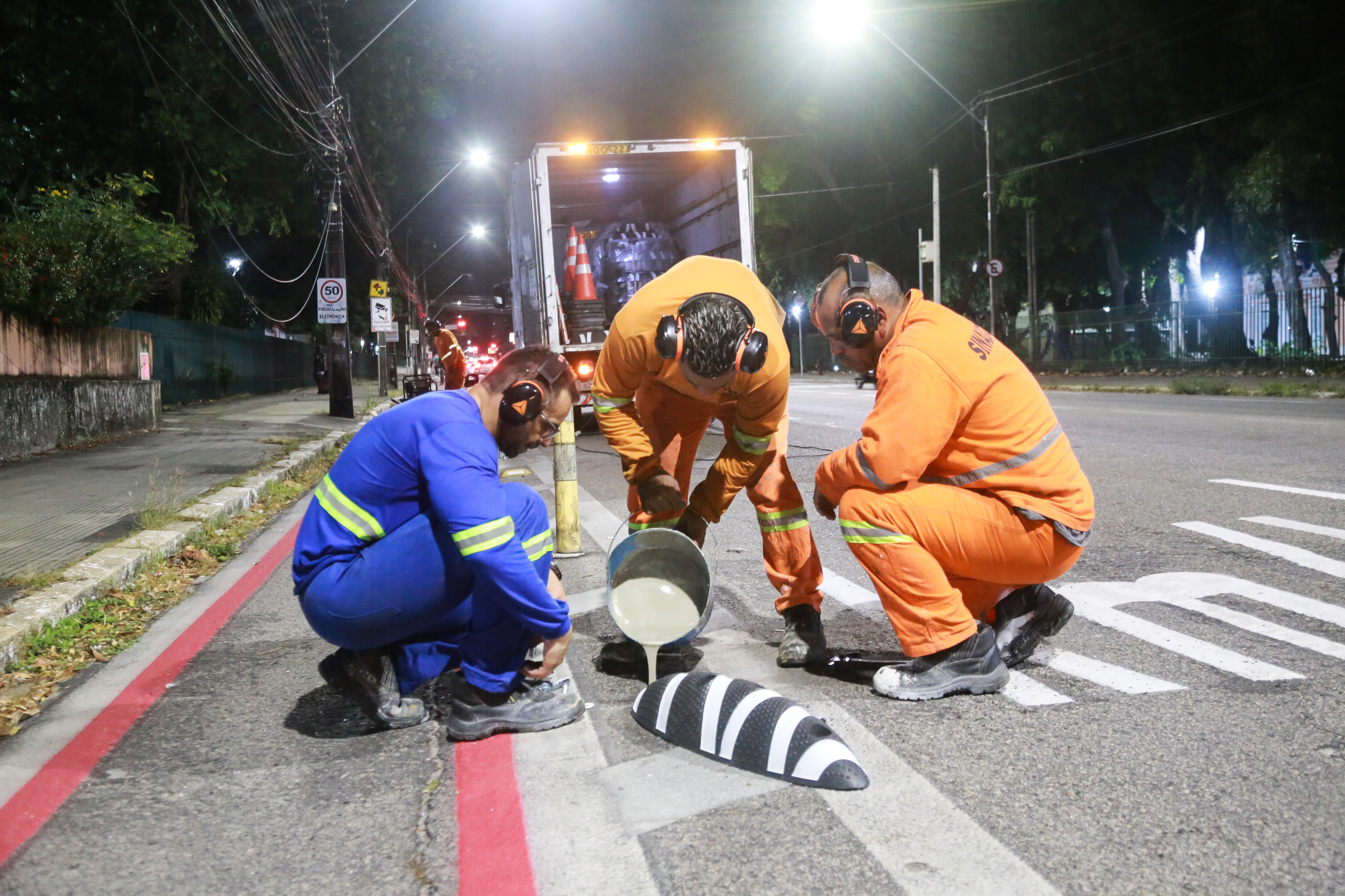 homens instalando dispositivo de sinalização, que horizontal e preto e branco